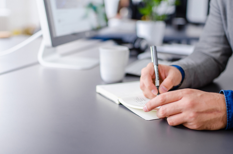 Business writing in a notebook at work
